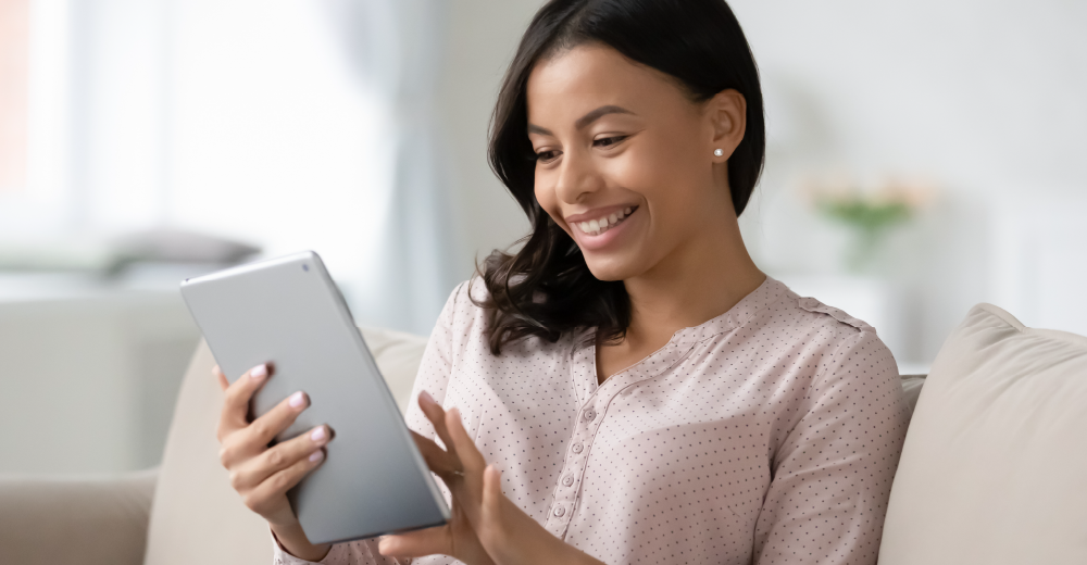 A women smiling while on a tablet
